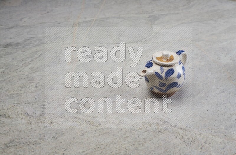 A pottery teapot on grey marble background
