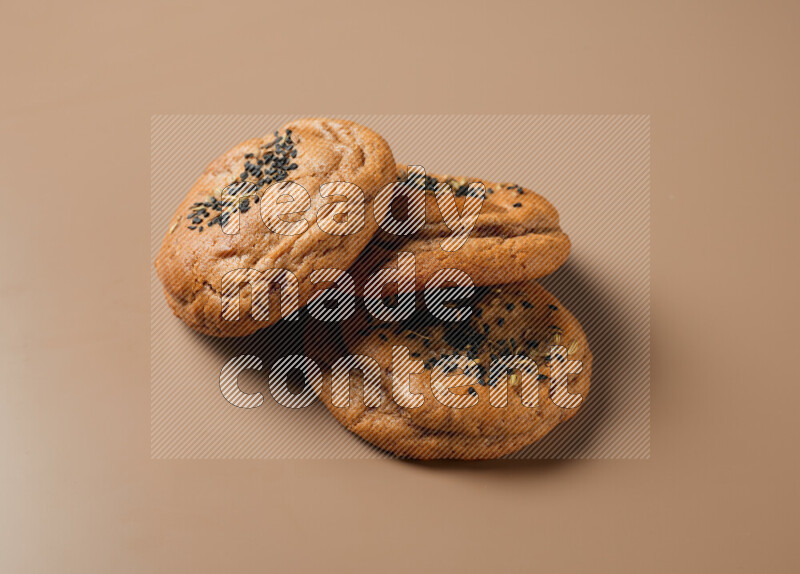 Hasawi cookies field with date and decorated by black seed and Anise grain on a brown background