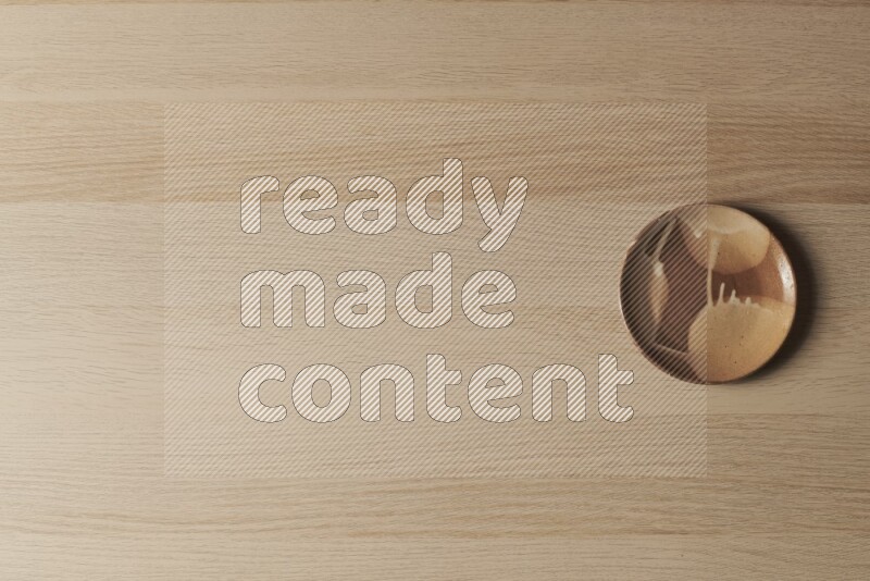 A multicolored pottery plate on light wooden background