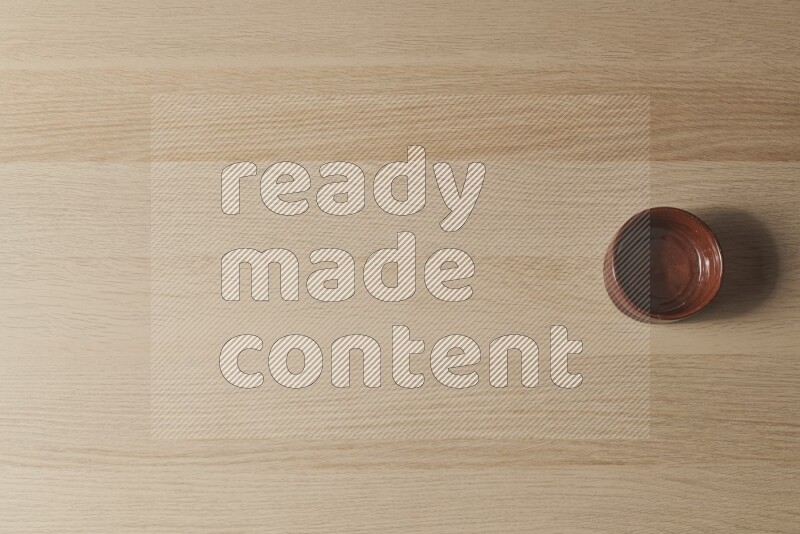 وعاء فخاري بني على خلفية خشبية فاتحة