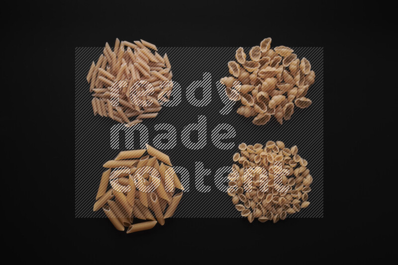 Different pasta types in bunches on black background