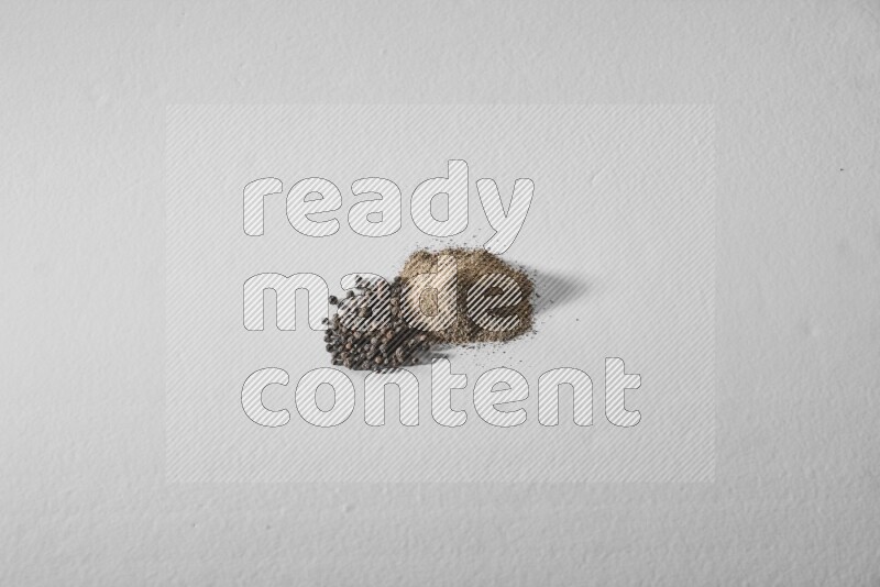Black pepper powder and beads on a white background