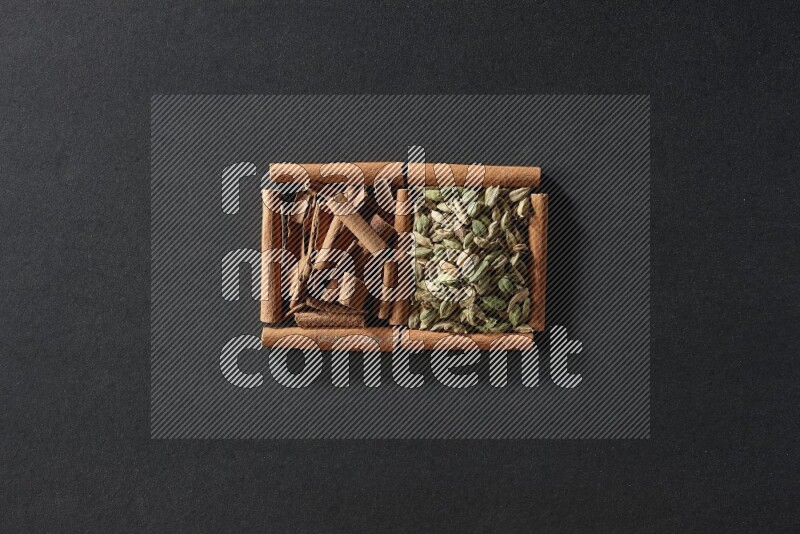 2 squares of cinnamon sticks full of cardamom and cinnamon on black flooring