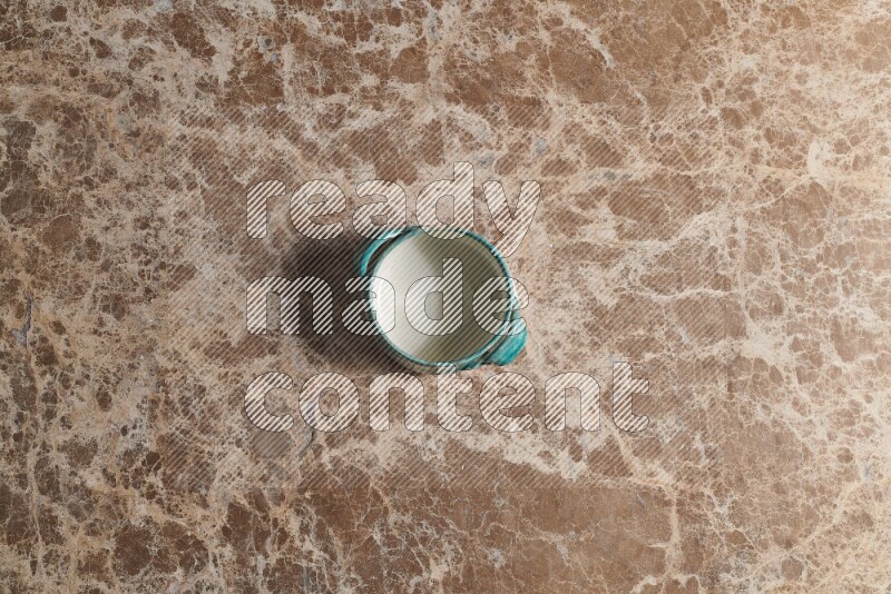 A multicolored pottery bowl on beige marble background