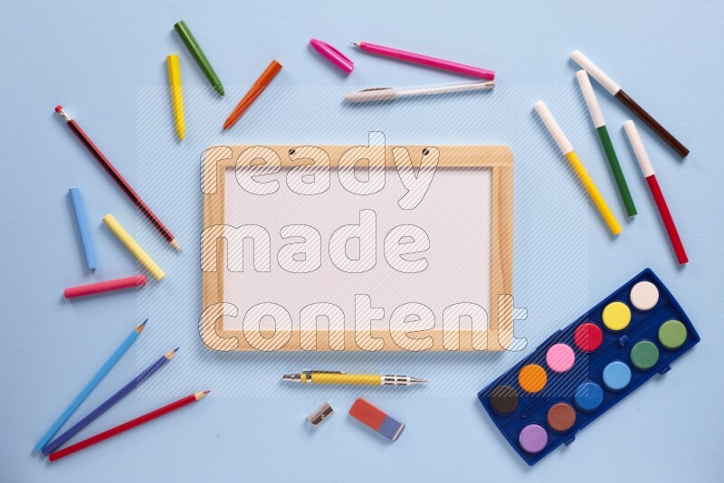 A whiteboard with assorted school supplies on blue background