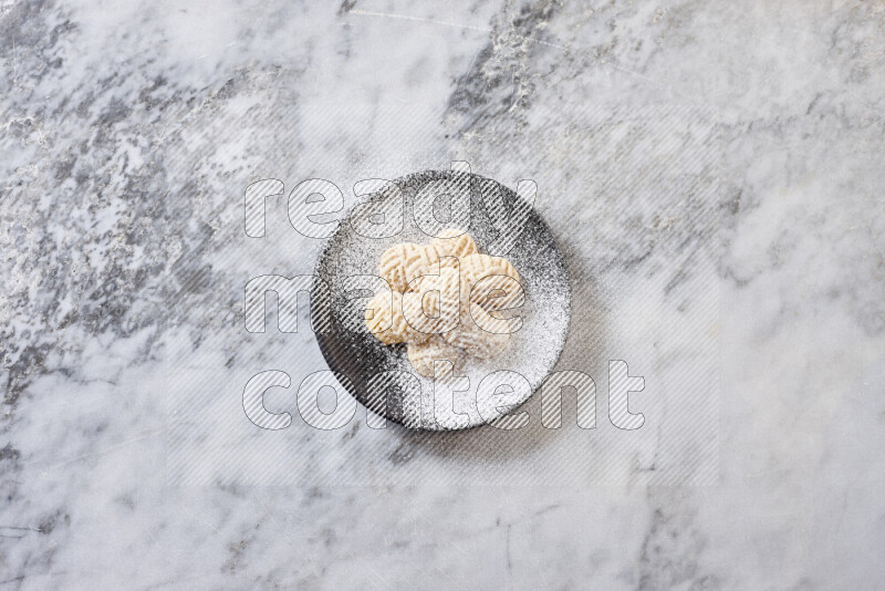 Kahk in black pottery plate on grey marble background