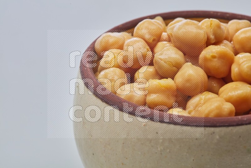 Close up shot of boiled chickpeas in a container on white background