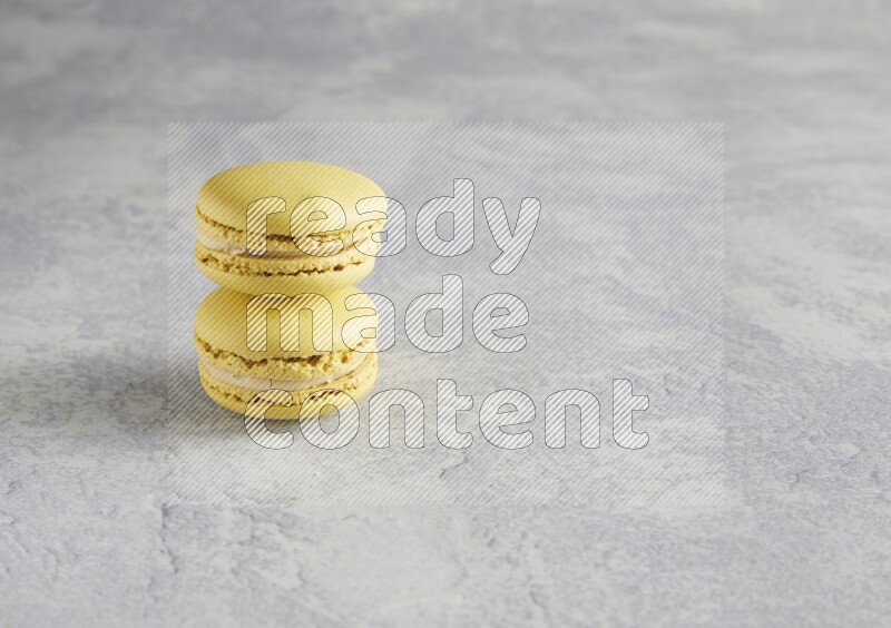 45º Shot of two Yellow Lime macarons  on white  marble background