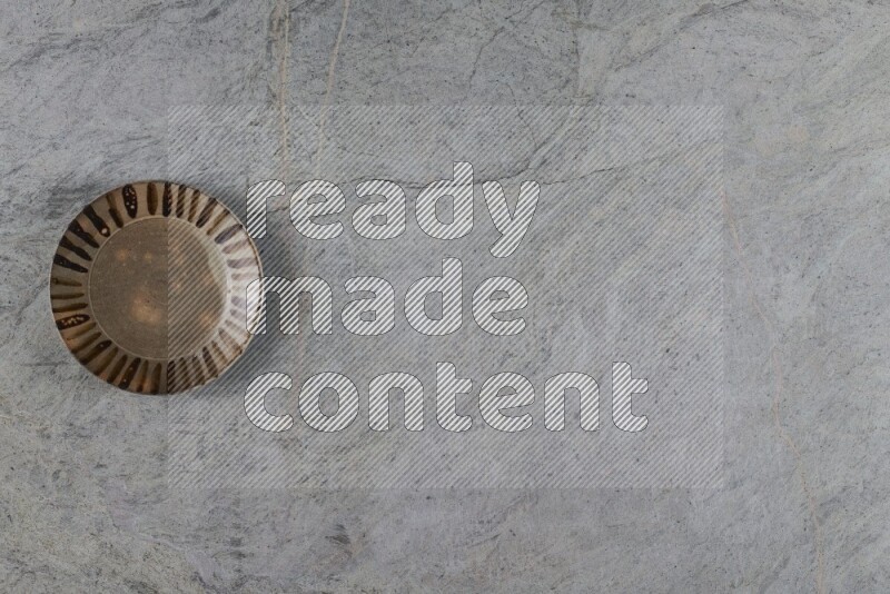 A multicolored pottery plate on grey marble background