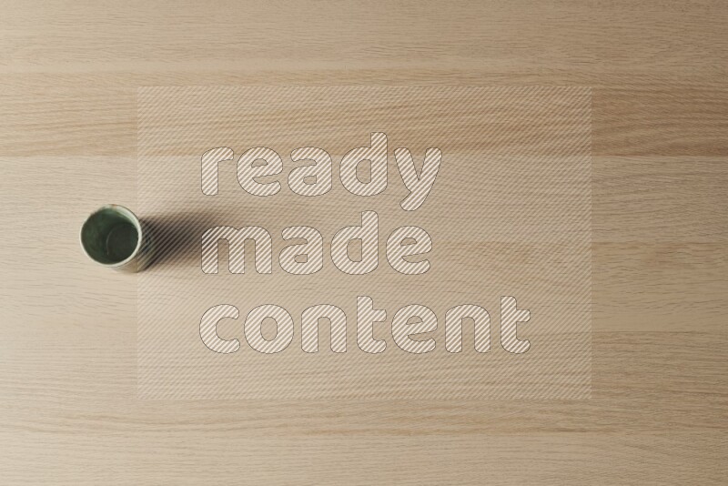 كأس فخاري على خلفية خشبية فاتحة