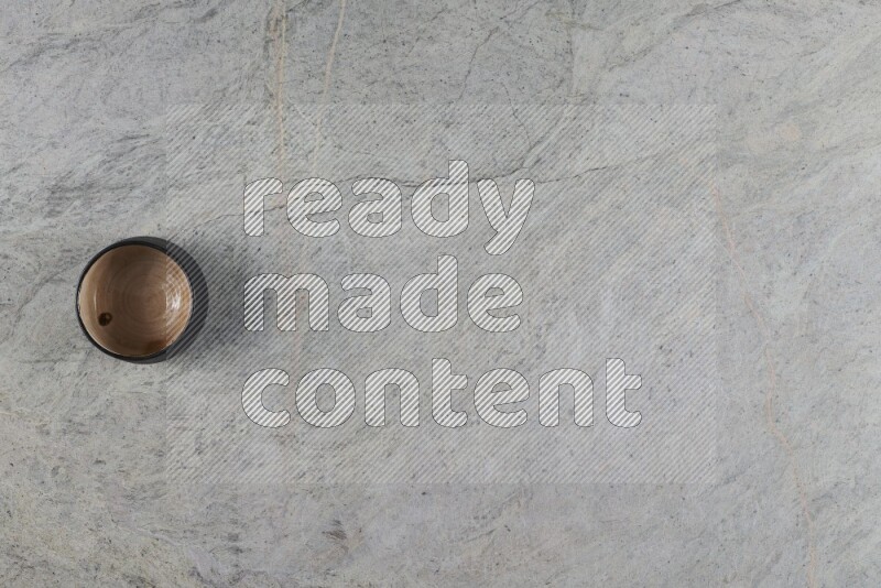 وعاء فخاري متعدد الألوان على خلفية من الرخام الرمادي