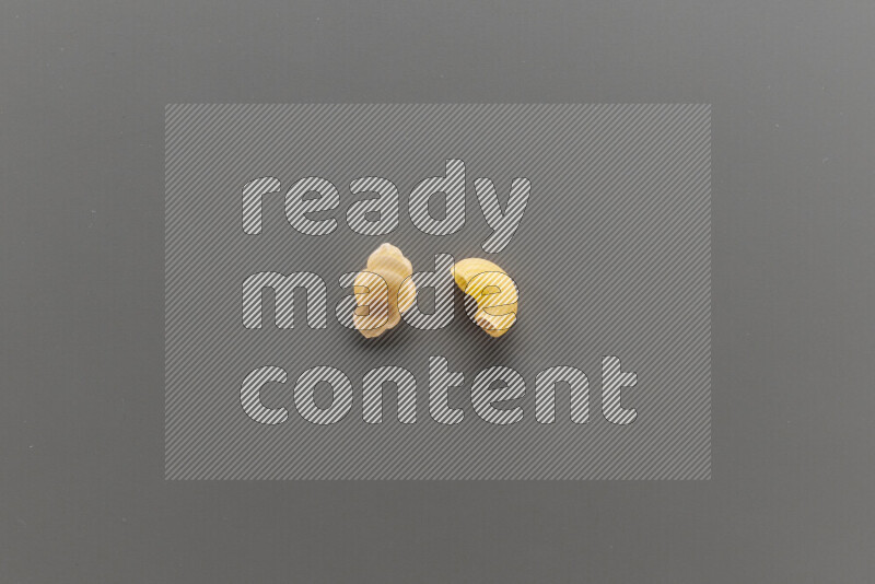 Snails pasta with other types of pasta on grey background