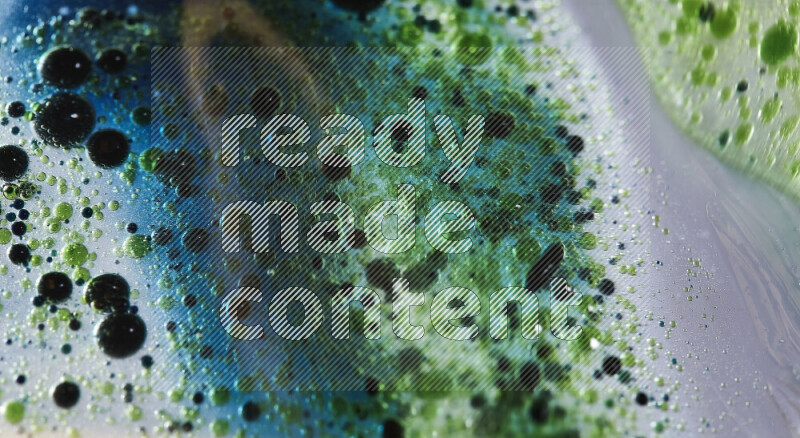 Close-ups of abstract green and blue watercolor drops on oil Surface on white background