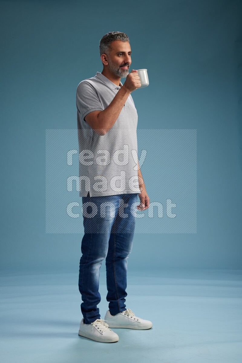 Man Standing drinking coffee on blue background