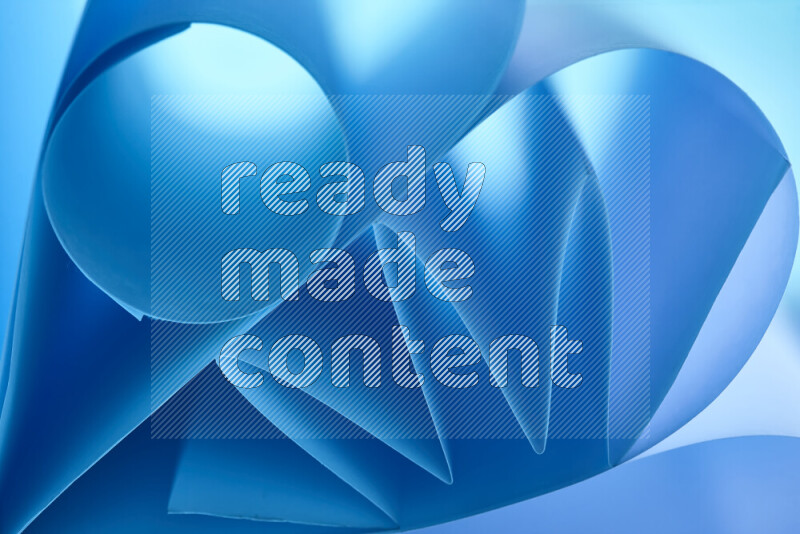 عرض فني لطيات الورق تخلق مزيج من الأشكال الهندسية، مضاءة بإضاءة ناعمة بدرجات اللون الأزرق