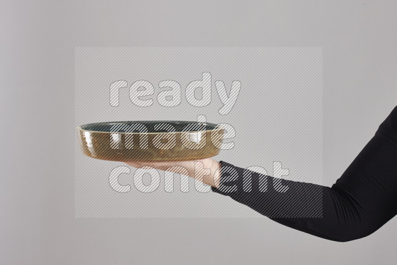 A woman in black abaya holding different pottery essentials in different positions