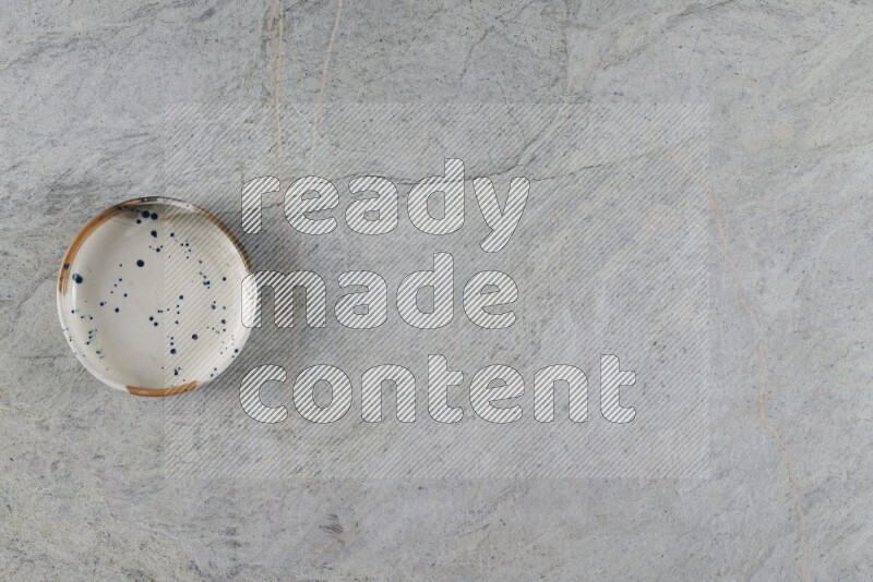 وعاء فخاري متعدد الألوان على خلفية من الرخام الرمادي