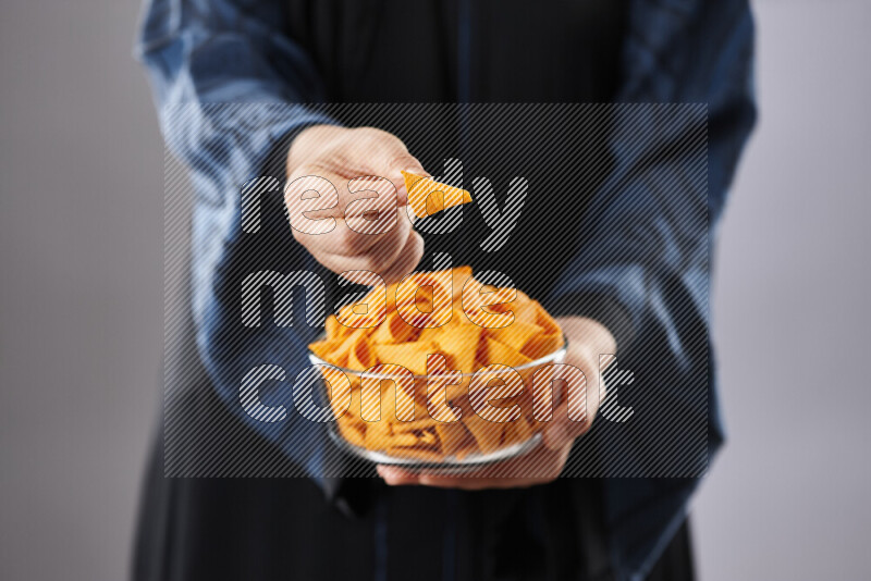 Woman in abaya holding different kinds of snacks in different positions