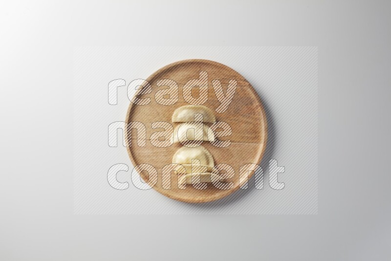 Five Sambosas on a wooden round plate on a white background
