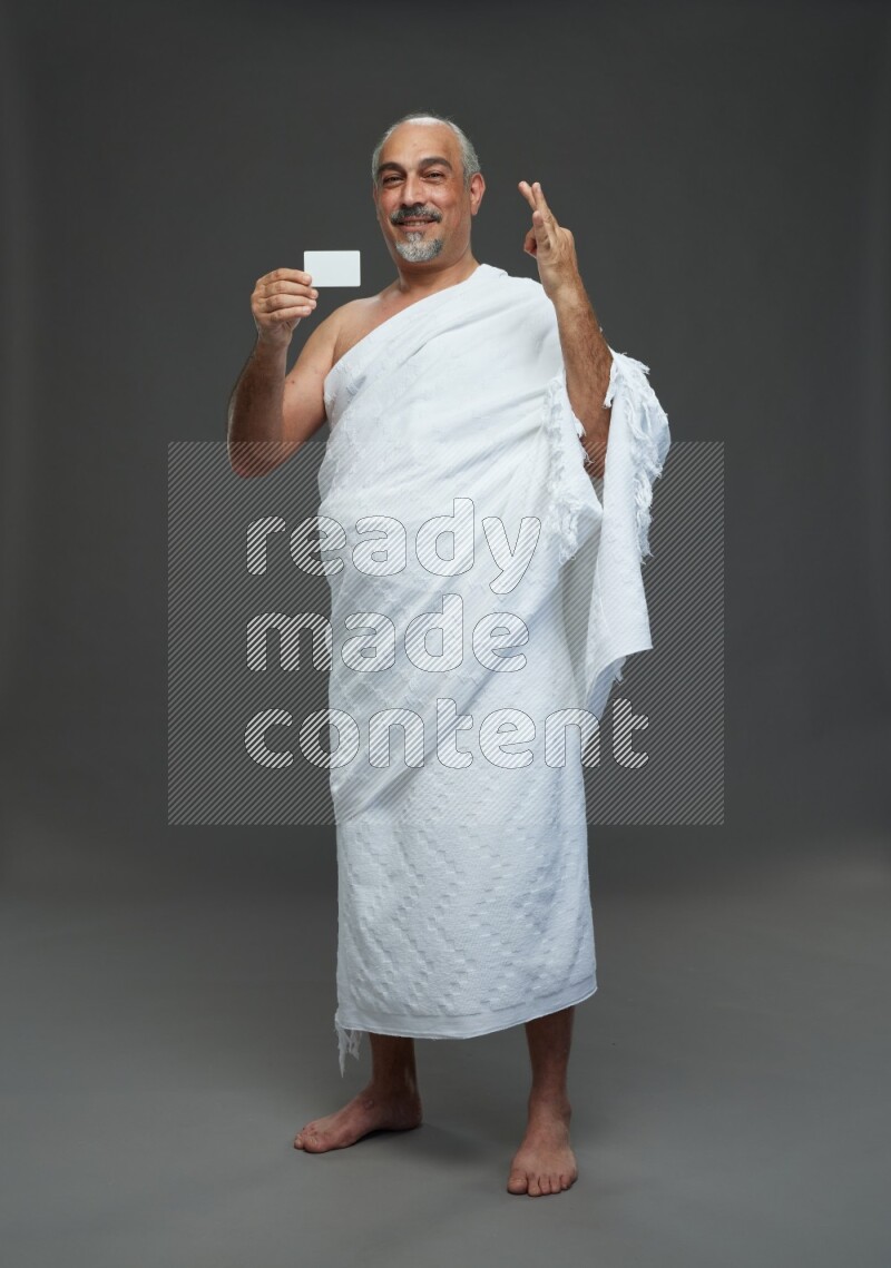 A man wearing Ehram Standing holding ATM card on gray background