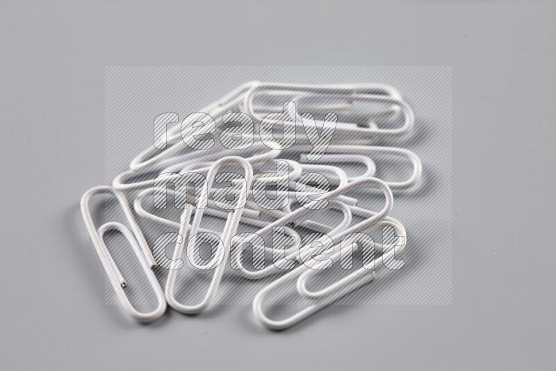 White paper clips isolated on a grey background