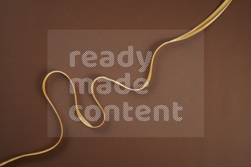 مجموعة من أدوات الخياطة والتفصيل صفراء اللون على خلفية بنية