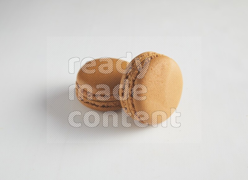 45º Shot of two Brown Maple Taffy macarons on white background