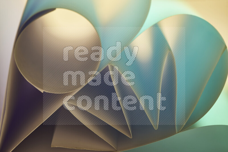 An artistic display of paper folds creating a harmonious blend of geometric shapes, highlighted by soft lighting in green and warm tones