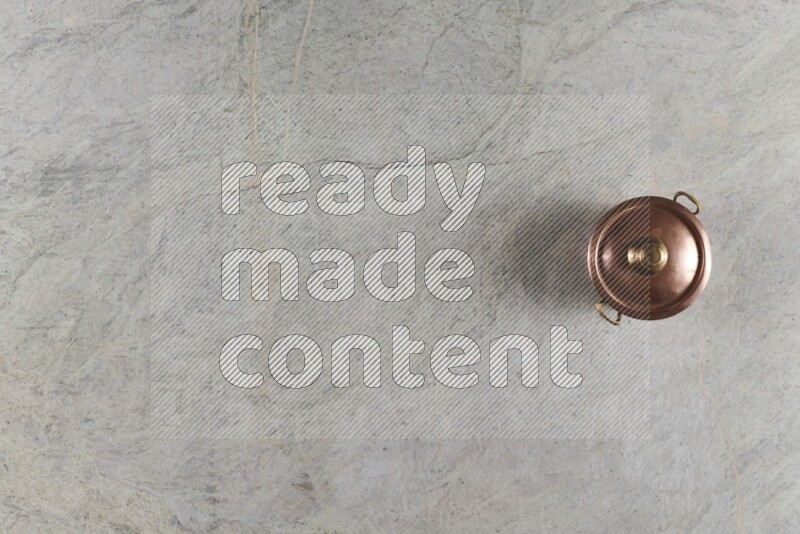 وعاء نحاسي صغير على خلفية من الرخام الرمادي