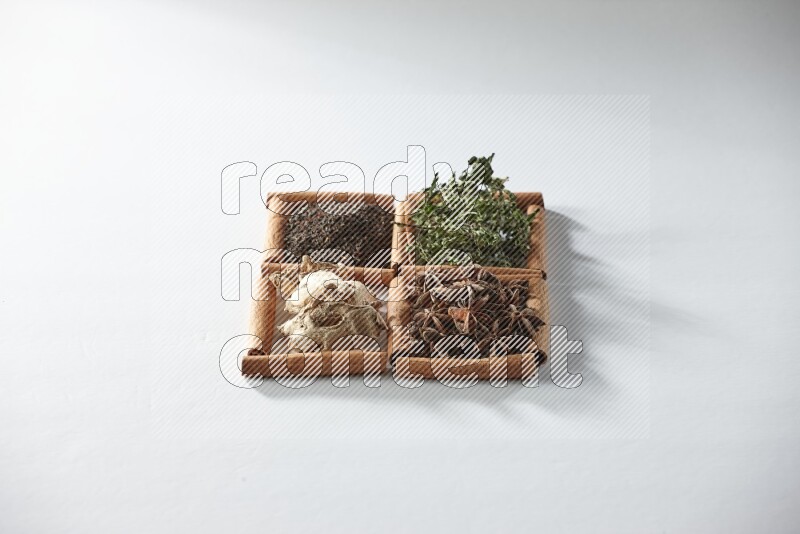 4 squares of cinnamon sticks full of tea, mint, star anise and ginger on white flooring
