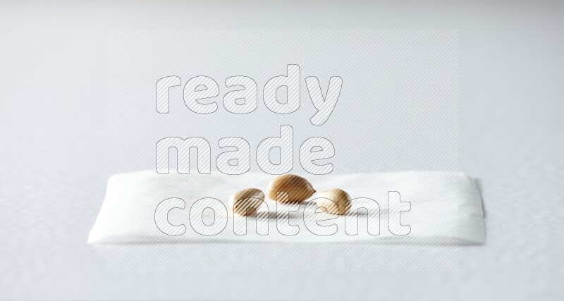 3 peeled peanuts on a piece of paper on a white background in different angles