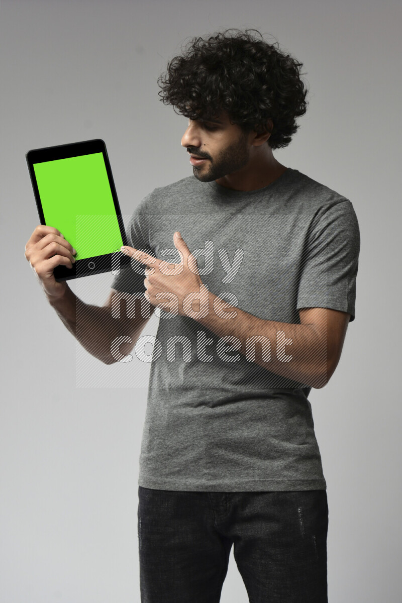 A man wearing casual standing and showing a tablet screen on white background