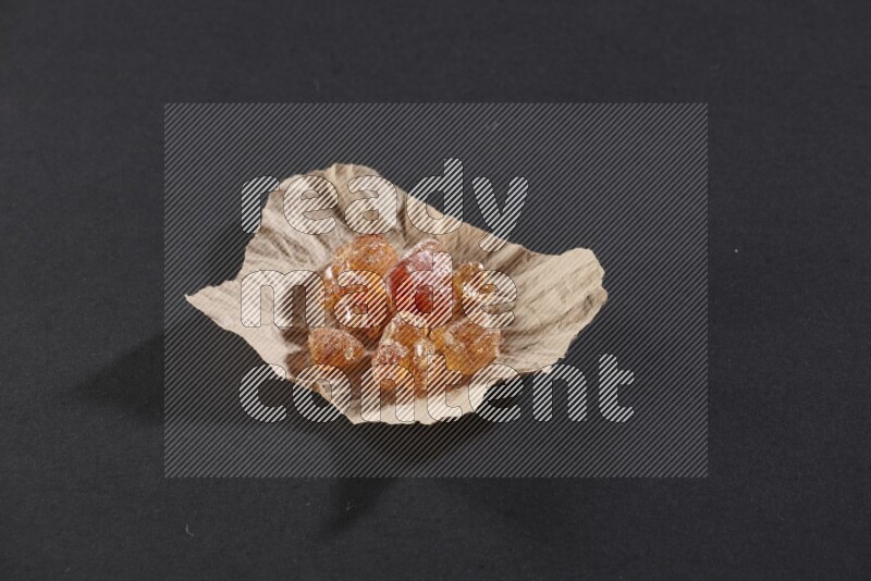 قطعة من الورق المجعد ممتلئة بالصمغ العربي علي خلفية سوداء