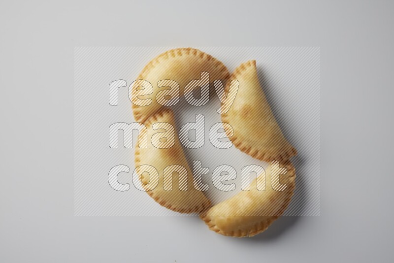 Four fried sambosa from a top angle on a white background