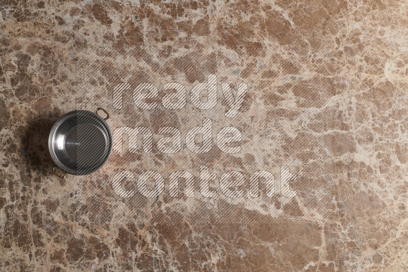 A small copper pot on beige marble background