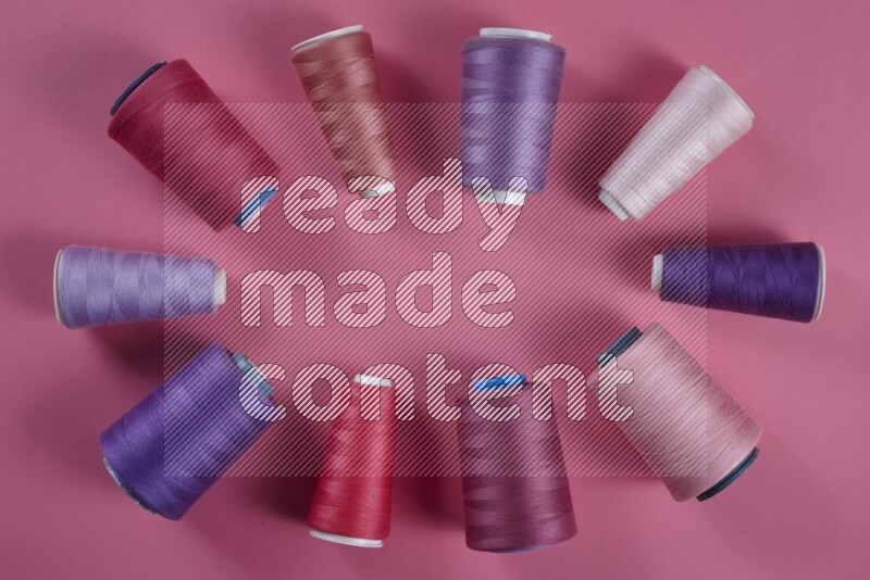 A purple and pink collection of sewing and tailoring tools arranged on a pink background