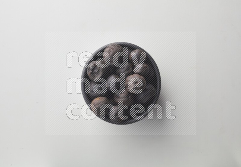 Top-view shot of dried lime (loomi) in a container on white background