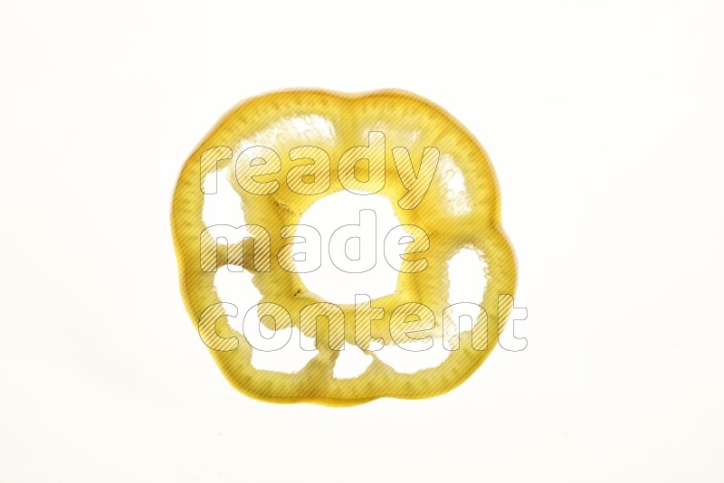 Yellow bell pepper slices on illuminated white background