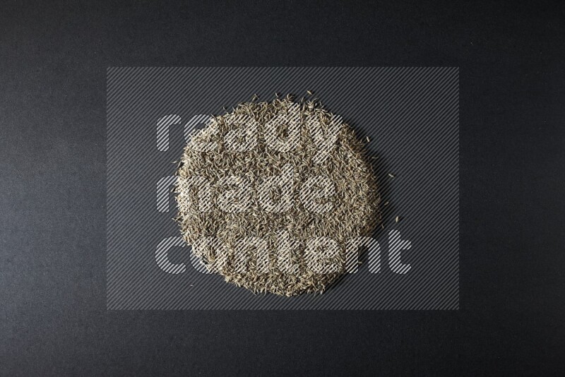 Cumin seeds on black flooring