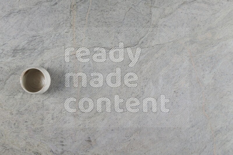 كأس فخاري متعدد الألوان على خلفية من الرخام الرمادي