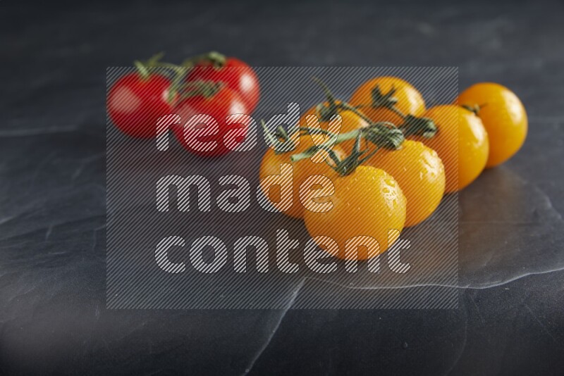 Mixed cherry tomato veins on a textured black slate background 45 degree