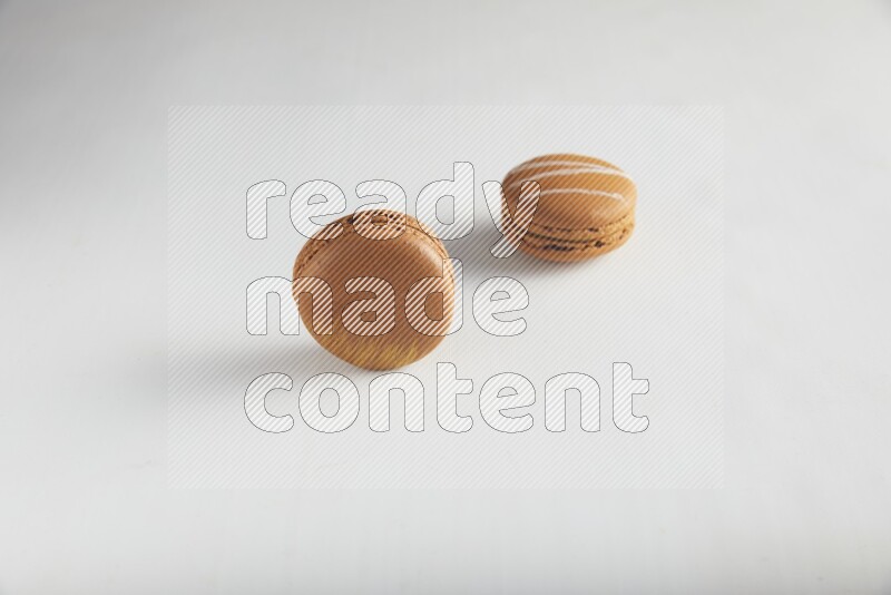 45º Shot of of two assorted Brown Irish Cream, and Brown Coffee macarons  on white background