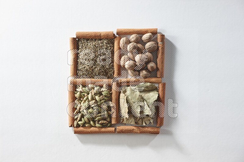 4 squares of cinnamon sticks full of nutmegs, bay laurel leaves, cardamom and cumin on white flooring