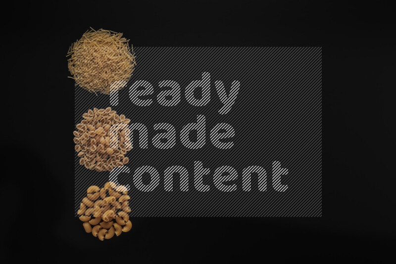 Different pasta types in 3 bunches on black background