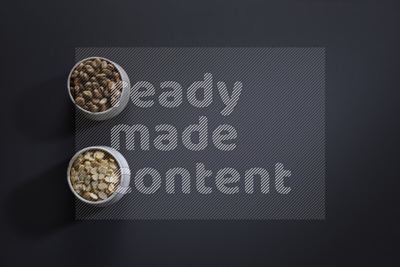 Legumes in pottery bowls on grey background