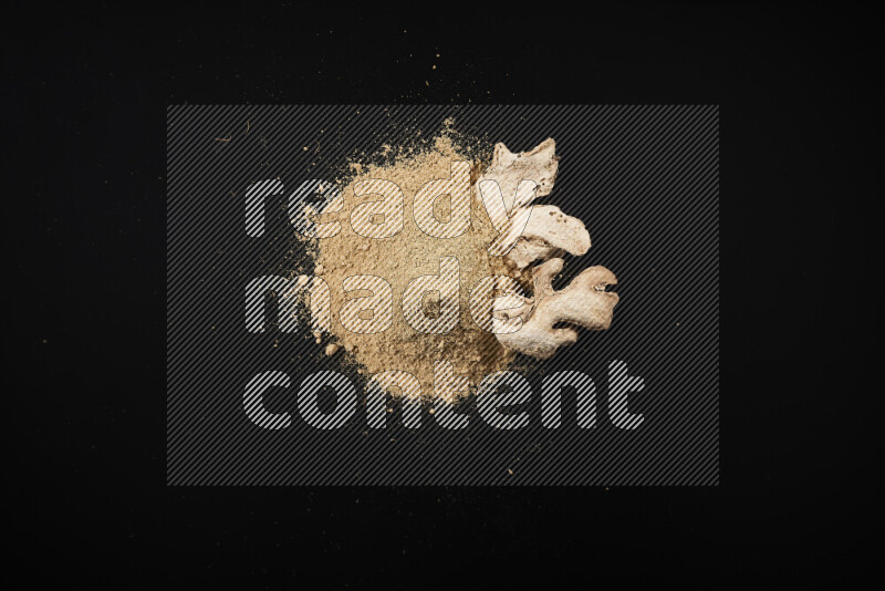 A bunch of ground ginger powder on black background