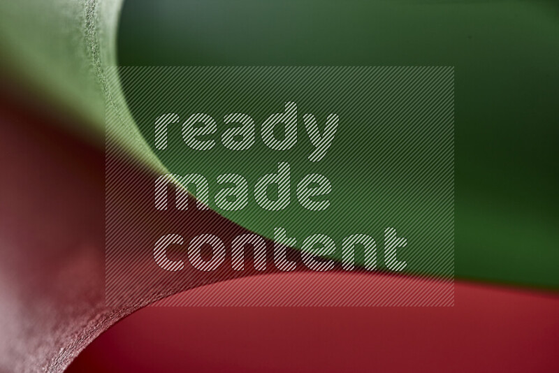 An abstract art showing red and green paper sheets arranged in an overlapping curves