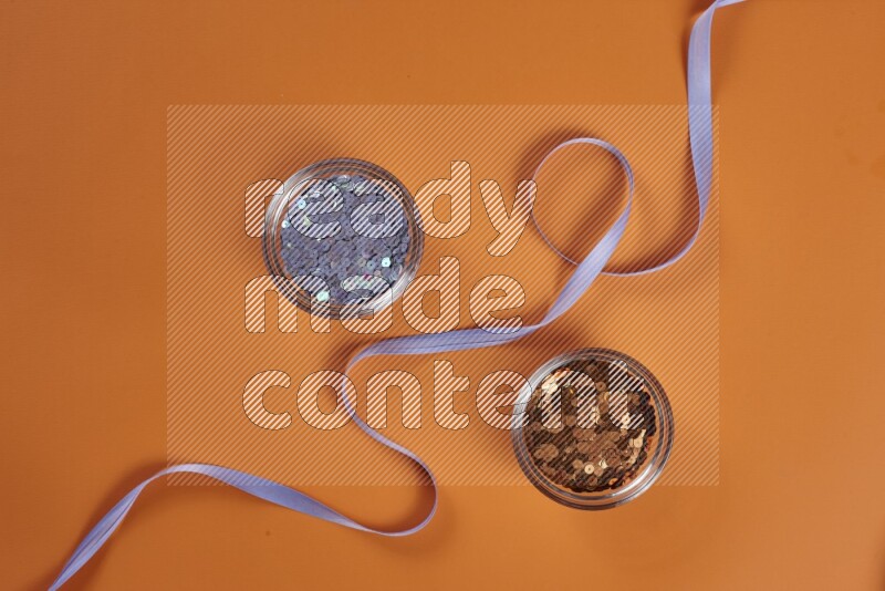 مجموعة من أدوات الخياطة والتفصيل أرجوانية اللون على خلفية برتقالية