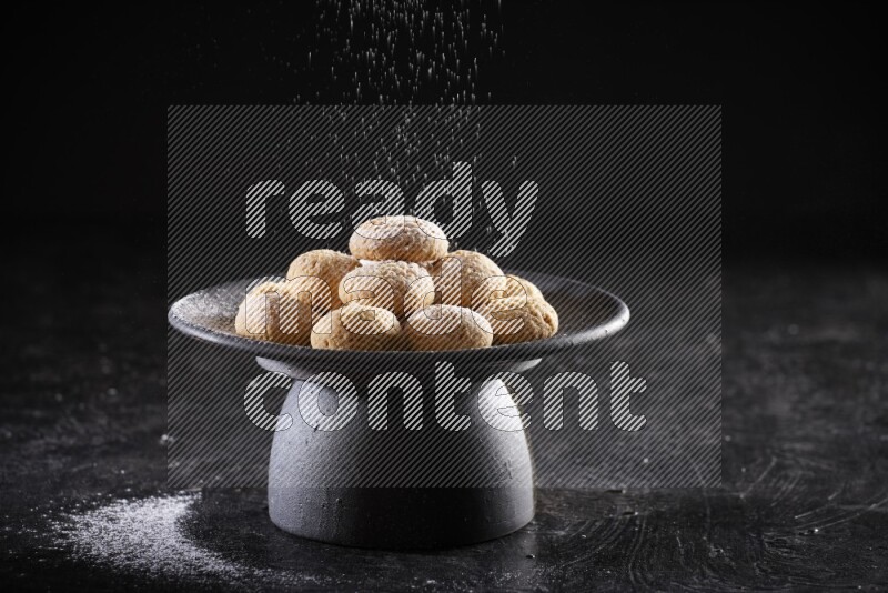 Kahk on a serving plate on a black background