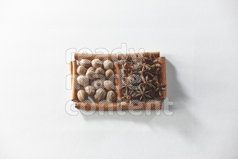 2 squares of cinnamon sticks full of star anise and nutmeg on white flooring
